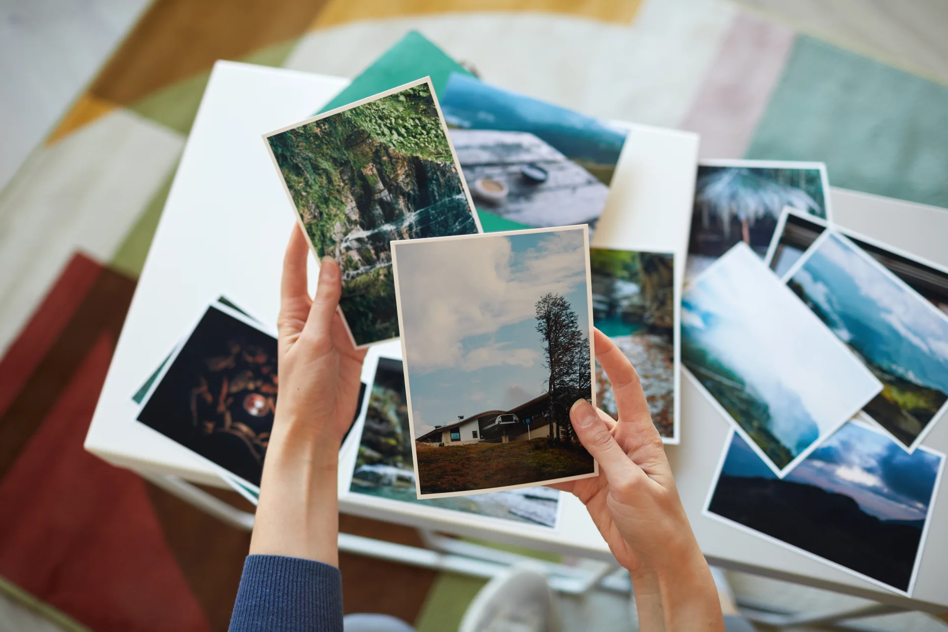 Ruky vyberajú reálne vytlačené fotografie v domácom prostredí